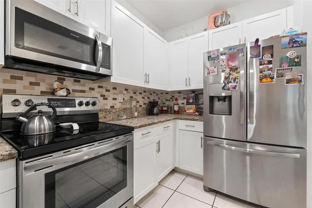 a kitchen with stainless steel appliances granite countertop a stove microwave and refrigerator