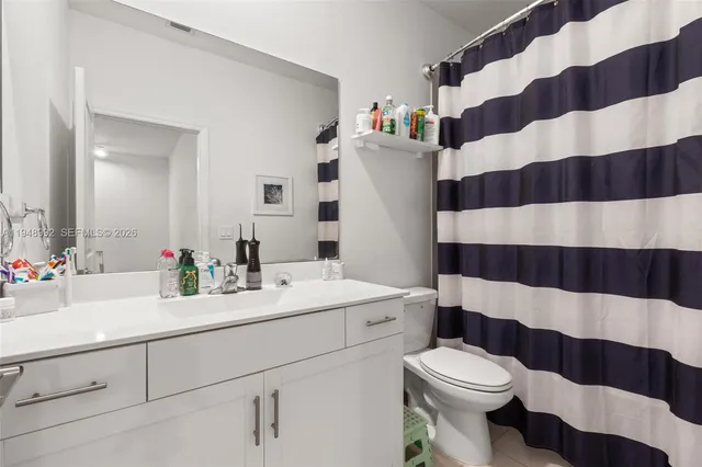a bathroom with a sink a toilet a shower curtain