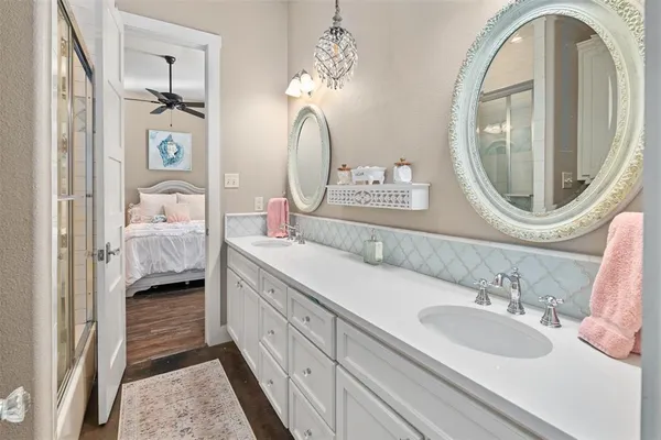a en suite bathroom with a double vanity sink and a mirror