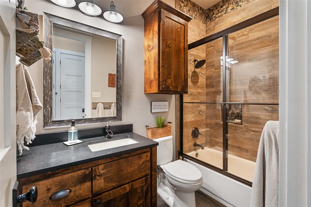 107 Nautical Point Mabank, TX 75143 - Photo 26 of 36 a bathroom with a granite countertop sink toilet a mirror and shower