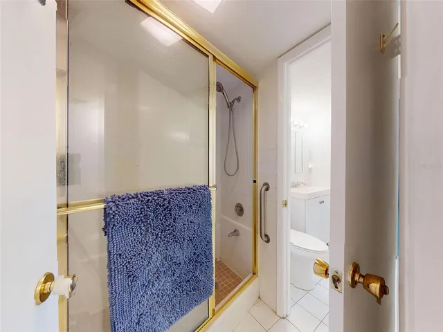a bathroom with a granite countertop shower and a mirror