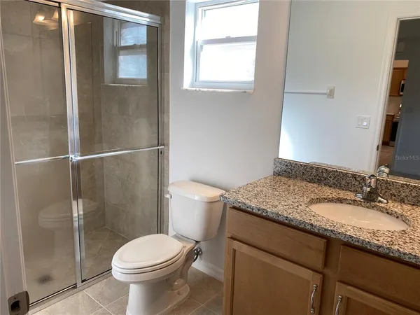 a bathroom with a granite countertop sink a toilet and bathtub