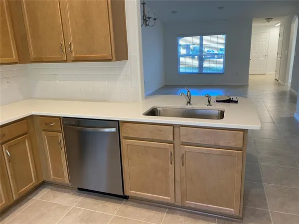 a view of a kitchen with fridge and wooden floor