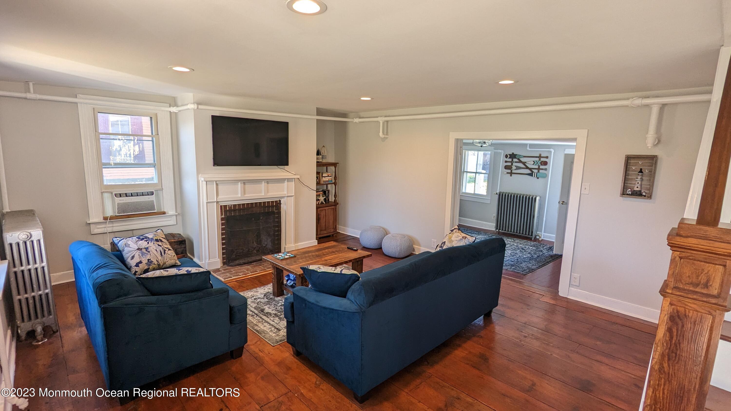 303 Baptist Road Newport, NJ 08345 - Photo 3 of 20 a living room with furniture a flat screen tv and a fireplace