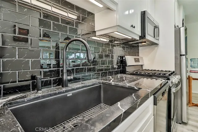 a kitchen with a sink a stove and a microwave