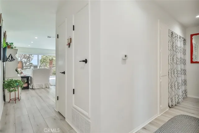 a view of a hallway with bathroom and wooden floor