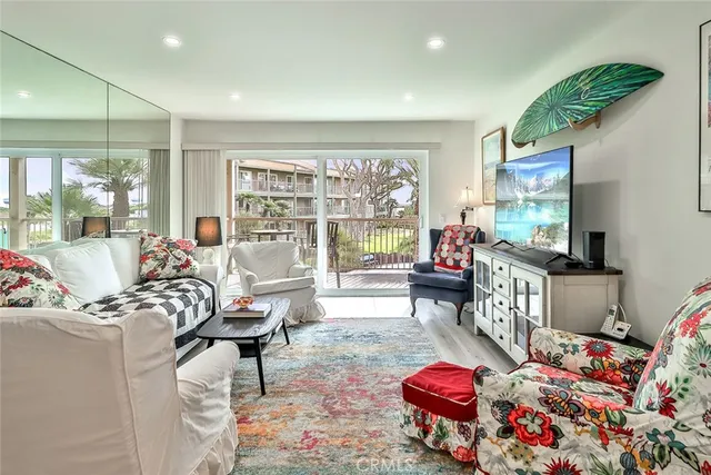 a living room with furniture a flat screen tv and a floor to ceiling window