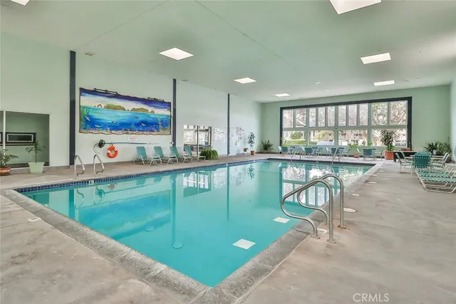 a indoor swimming pool with outdoor seating and windows
