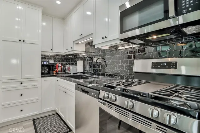 a kitchen with granite countertop a stove and a sink
