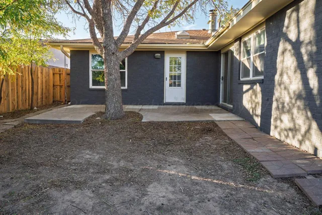 an empty room with wooden floor a fireplace and windows