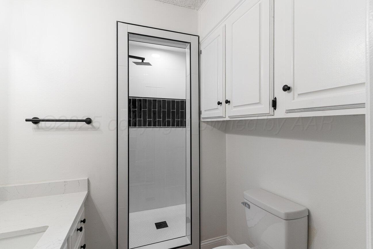 2607 15th Avenue Canyon, TX 79015 - Photo 26 of 54 a bathroom with a shower toilet and sink