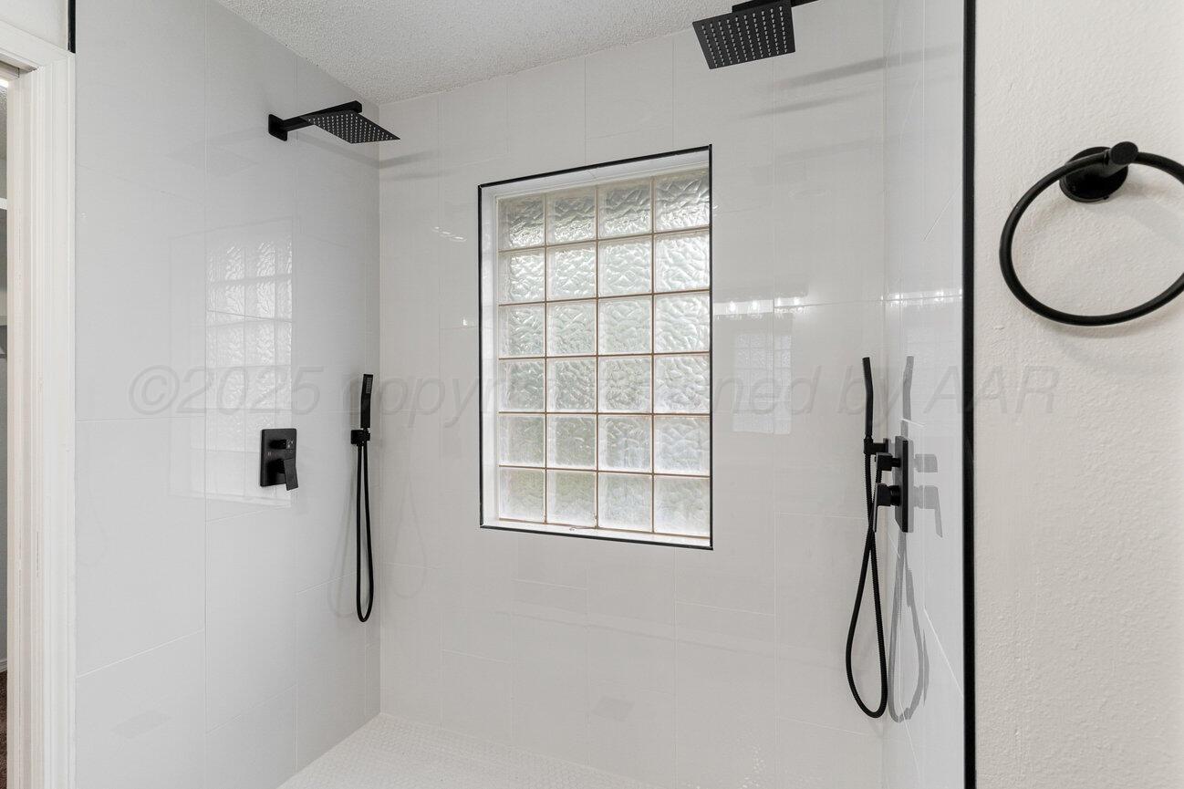 2607 15th Avenue Canyon, TX 79015 - Photo 31 of 54 a bathroom with a tub shower and a window
