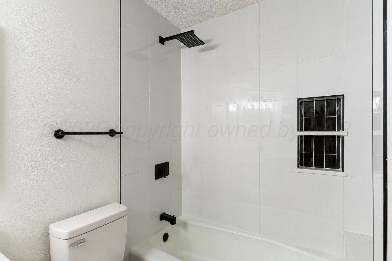 2607 15th Avenue Canyon, TX 79015 - Photo 33 of 54 a bathroom with a shower a toilet and a window