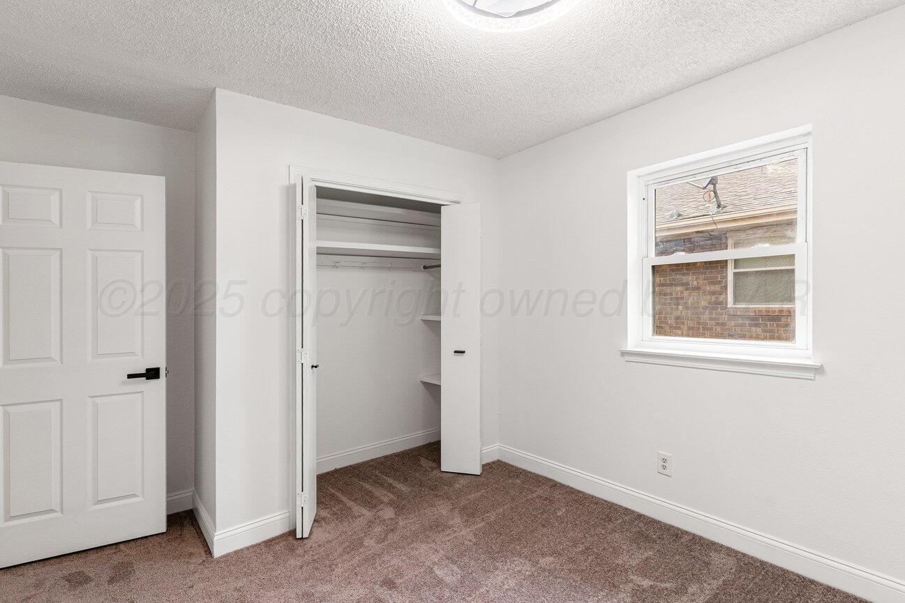2607 15th Avenue Canyon, TX 79015 - Photo 39 of 54 an empty room with windows and closet