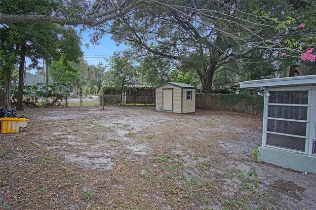 a view of a house with backyard and a tree