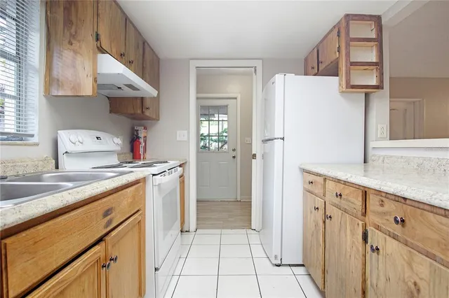 a kitchen with a sink a refrigerator and cabinets