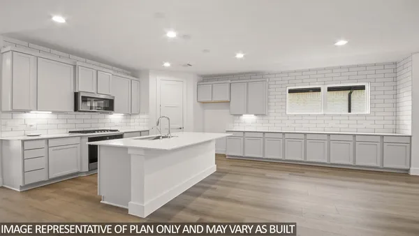 a large white kitchen with cabinets