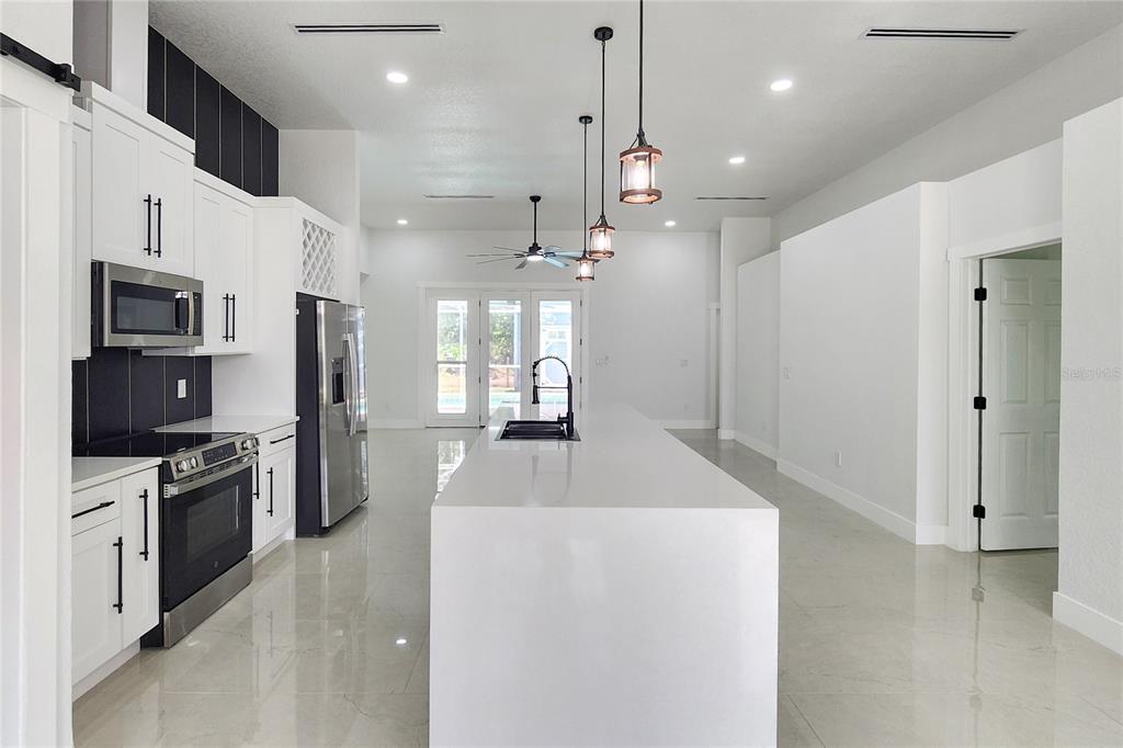 7027 Frascati Loop Wesley Chapel, FL 33544 - Photo 6 of 28 a kitchen with stainless steel appliances granite countertop a refrigerator a oven a sink a stove and a refrigerator