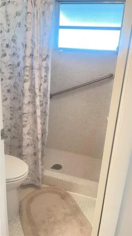 a bathroom with a toilet and a shower