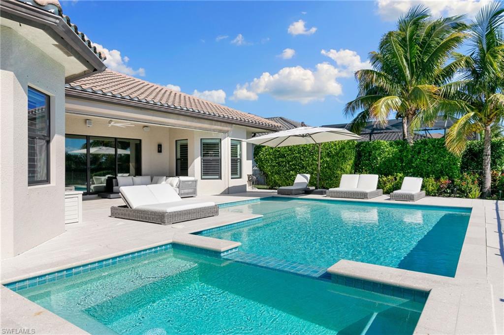 a view of a patio with couches table and chairs with potted plants and palm trees