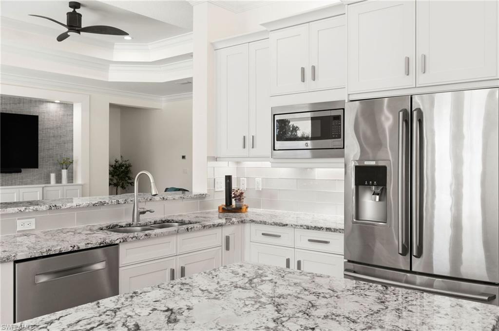 4308 Caldera Circle Naples, FL 34119 - Photo 11 of 44 a kitchen with stainless steel appliances granite countertop a refrigerator sink and stove