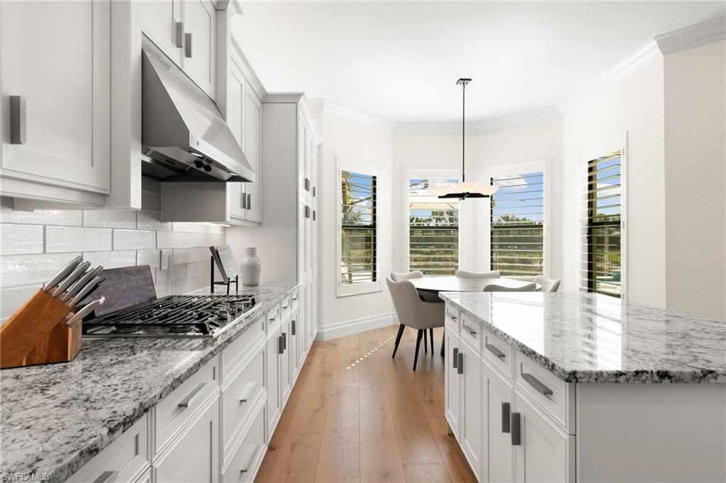 4308 Caldera Circle Naples, FL 34119 - Photo 13 of 44 a kitchen with stainless steel appliances granite countertop a stove a sink and a wooden floors