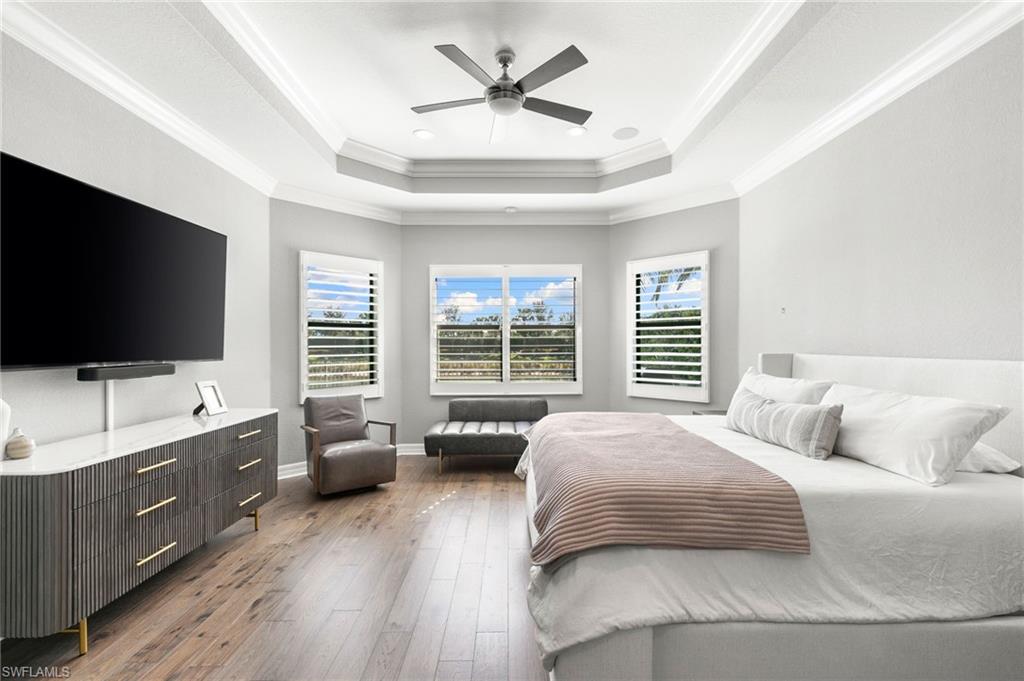 4308 Caldera Circle Naples, FL 34119 - Photo 18 of 44 a spacious bedroom with a large bed and a flat screen tv