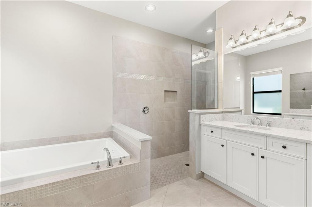 4308 Caldera Circle Naples, FL 34119 - Photo 20 of 44 a bathroom with a tub a sink and mirror