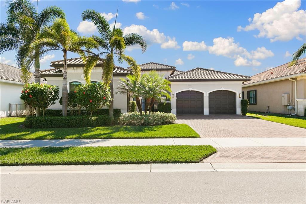 4308 Caldera Circle Naples, FL 34119 - Photo 2 of 44 a front view of a house with a garden and plants