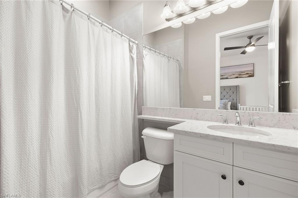 4308 Caldera Circle Naples, FL 34119 - Photo 26 of 44 a bathroom with a sink a toilet and shower curtain
