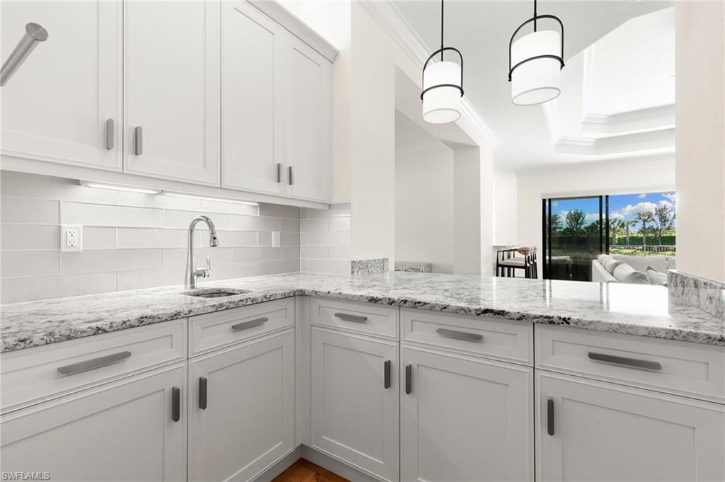 4308 Caldera Circle Naples, FL 34119 - Photo 29 of 44 a kitchen with white cabinets and white appliances