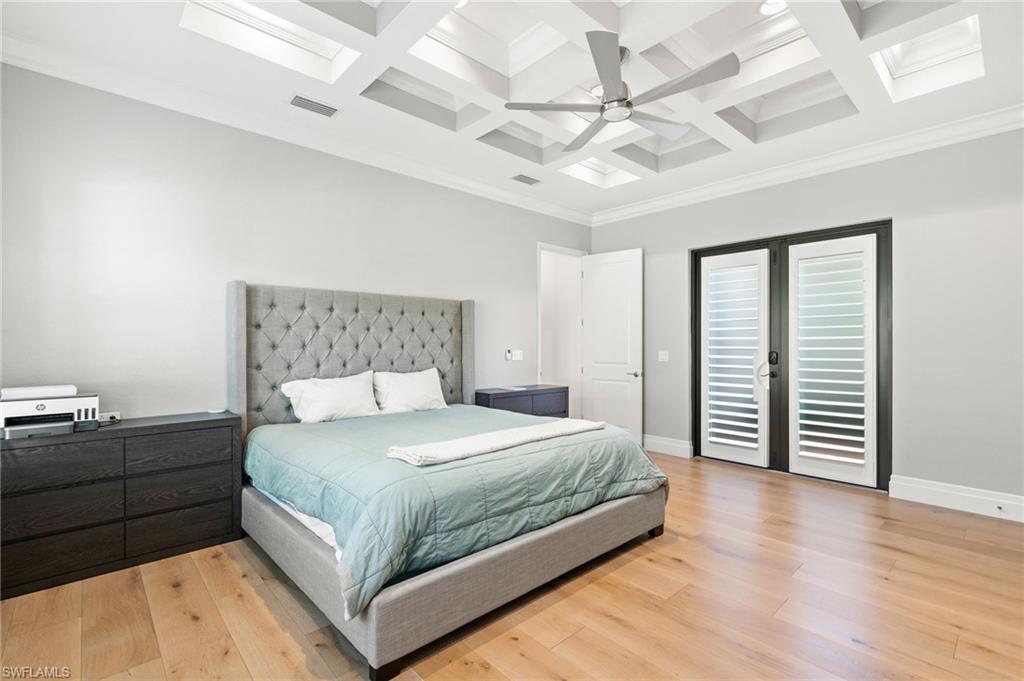 4308 Caldera Circle Naples, FL 34119 - Photo 30 of 44 a bedroom with a large bed and a chandelier