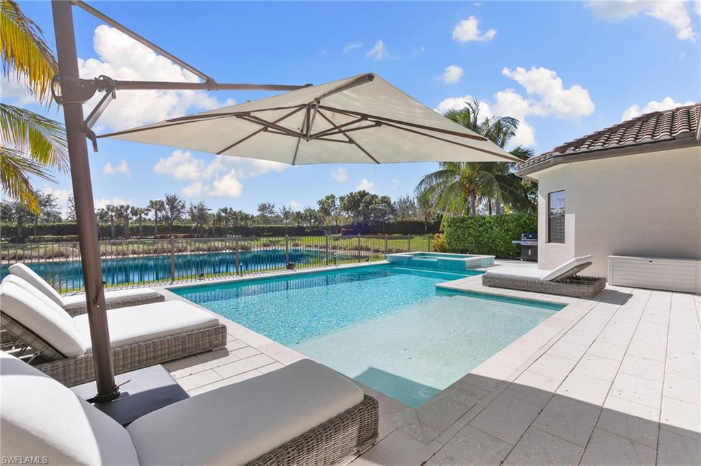 4308 Caldera Circle Naples, FL 34119 - Photo 35 of 44 a view of a lake with couches chairs and umbrella