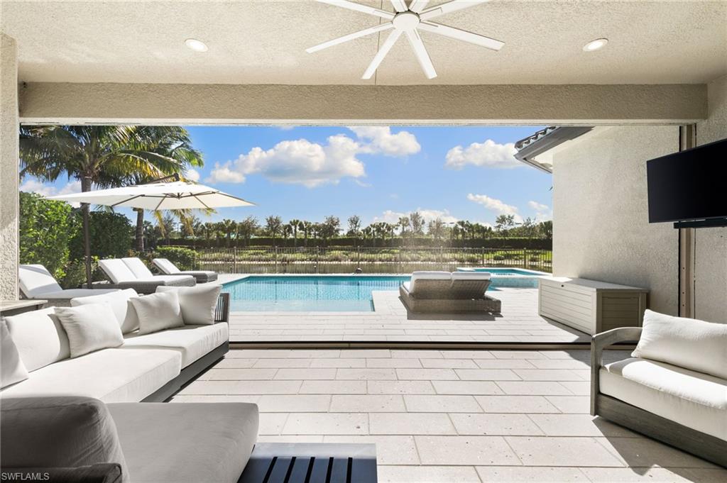 4308 Caldera Circle Naples, FL 34119 - Photo 39 of 44 a living room with furniture and a floor to ceiling window