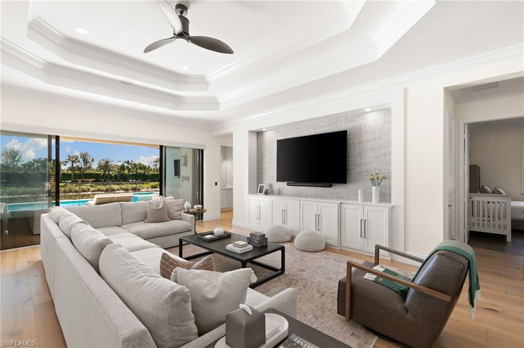 4308 Caldera Circle Naples, FL 34119 - Photo 6 of 44 a living room with furniture floor to ceiling window and a flat screen tv