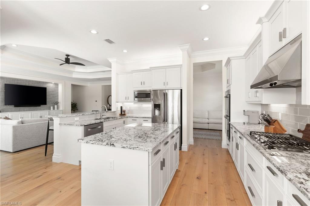 4308 Caldera Circle Naples, FL 34119 - Photo 10 of 44 a kitchen with stainless steel appliances kitchen island granite countertop a stove and a refrigerator