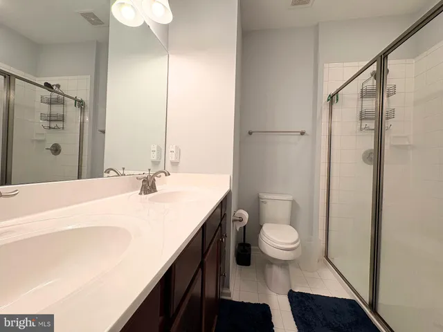 a bathroom with a sink a toilet a shower and a mirror
