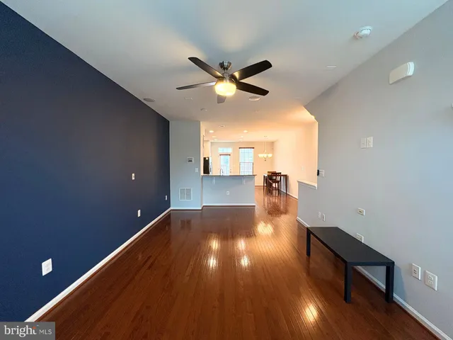 a view of a room with wooden floor and a ceiling fan