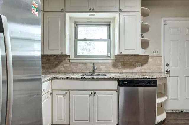 a bathroom with a granite countertop sink a toilet and a shower