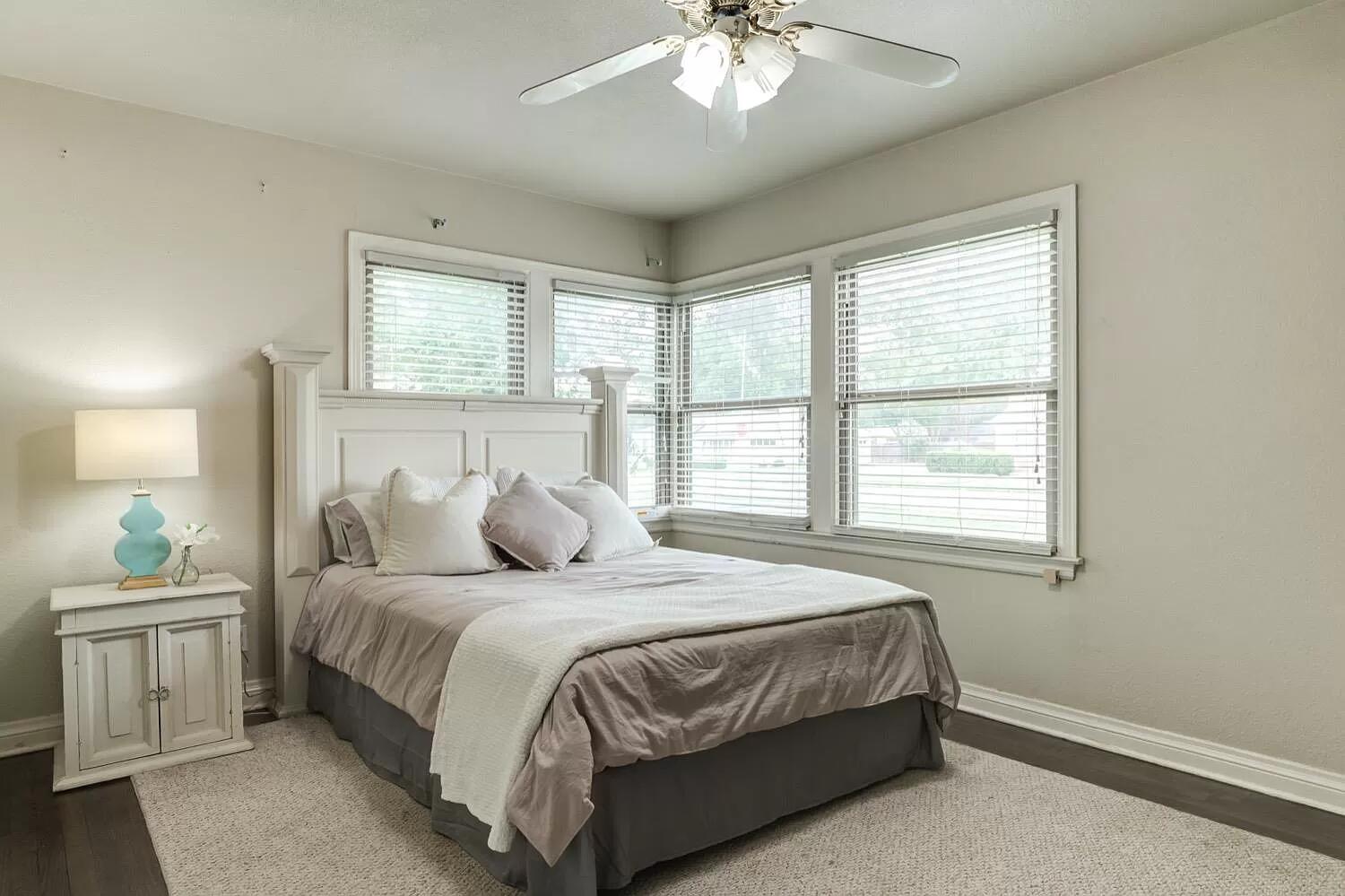 3204 28th Street Lubbock, TX 79410 - Photo 17 of 24 a bedroom with a large bed and a chandelier