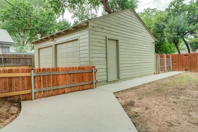 a view of a small house with wooden fence