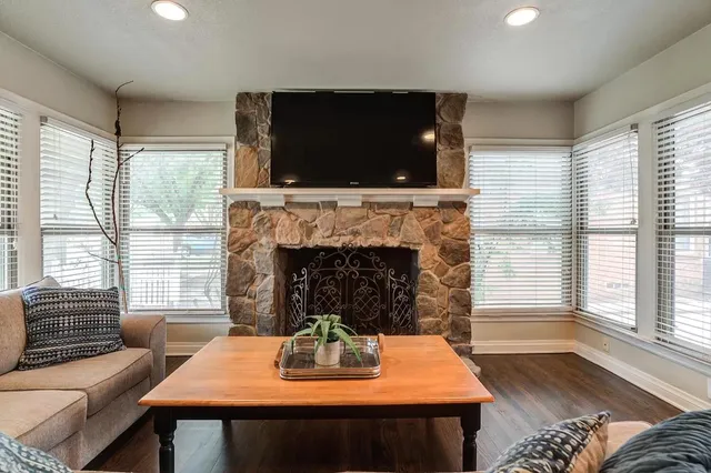a living room with furniture a flat screen tv and a fireplace