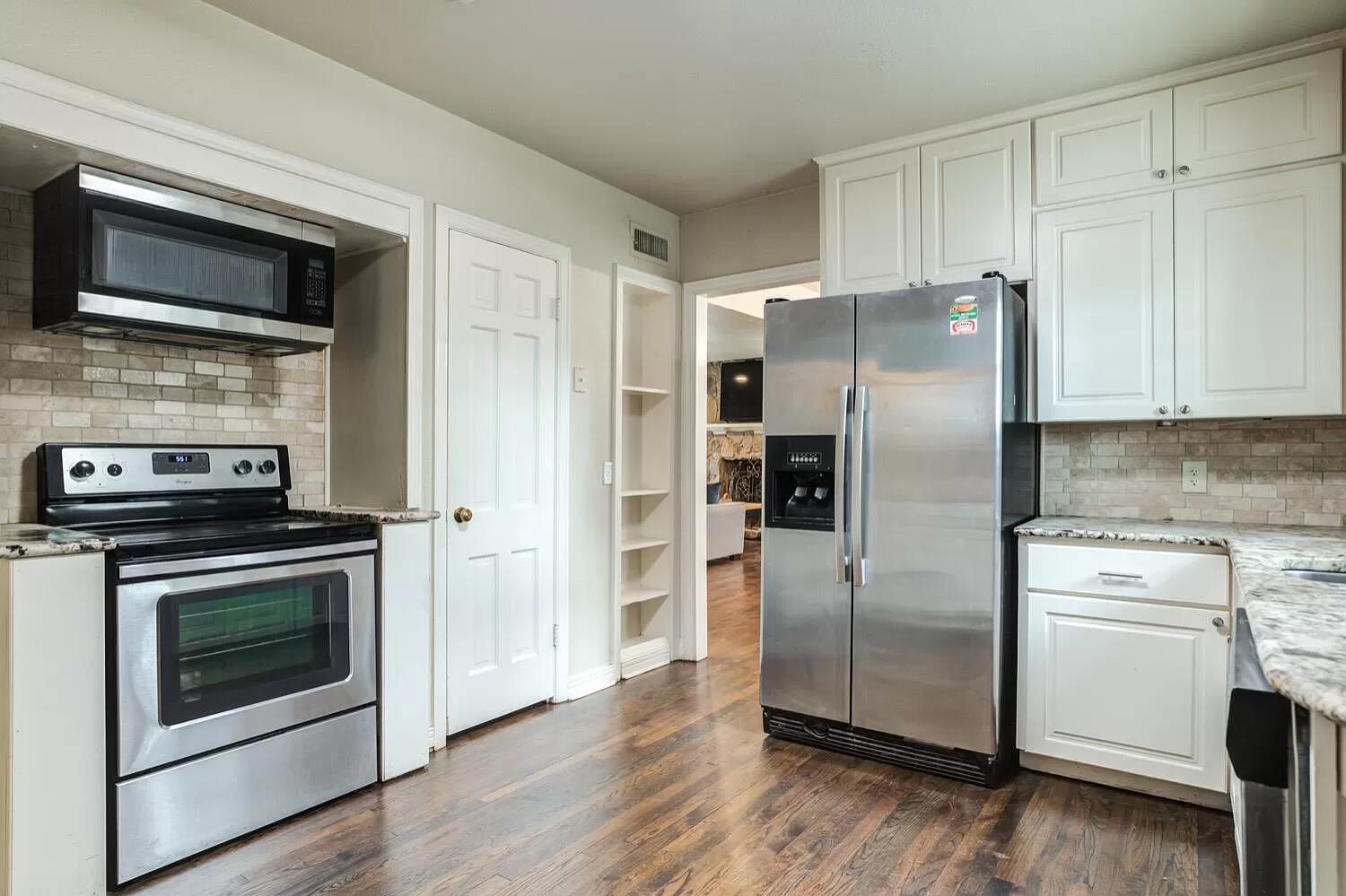 3204 28th Street Lubbock, TX 79410 - Photo 9 of 24 a kitchen with a stove microwave and refrigerator