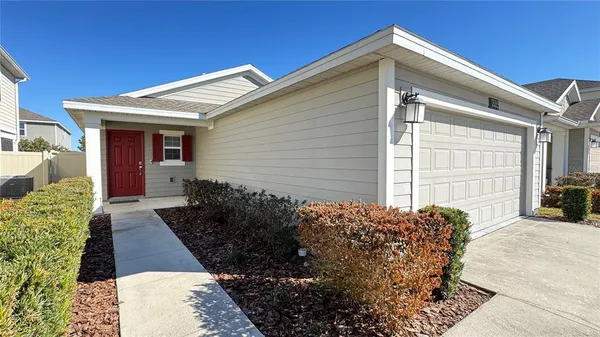 a view of a house with a small yard and potted plants