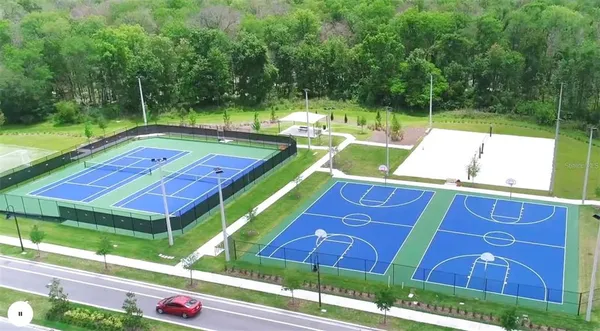 a view of a tennis ground with large trees