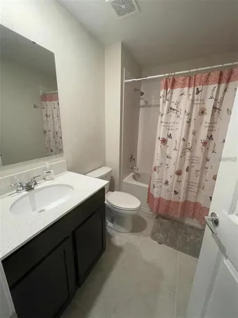 a bathroom with a sink a toilet and shower curtain