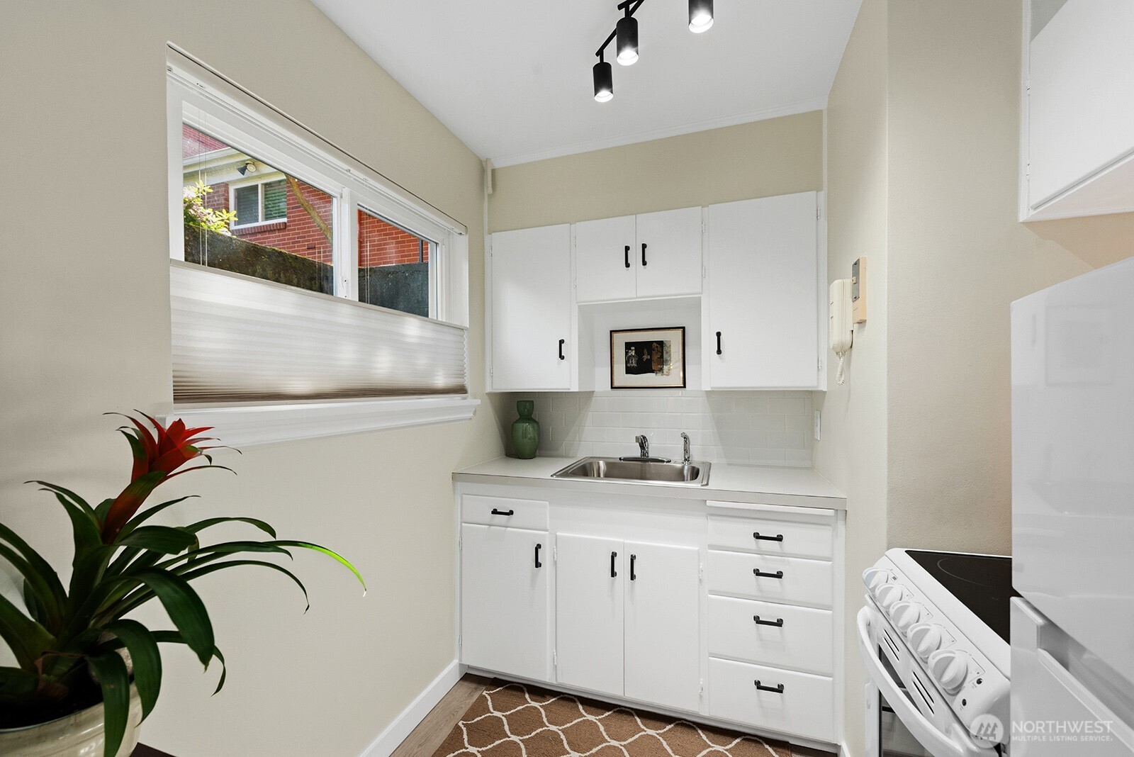 4407 Southwest Alaska Street, Unit 11 Seattle, WA 98116 - Photo 7 of 24 a kitchen with cabinets and window
