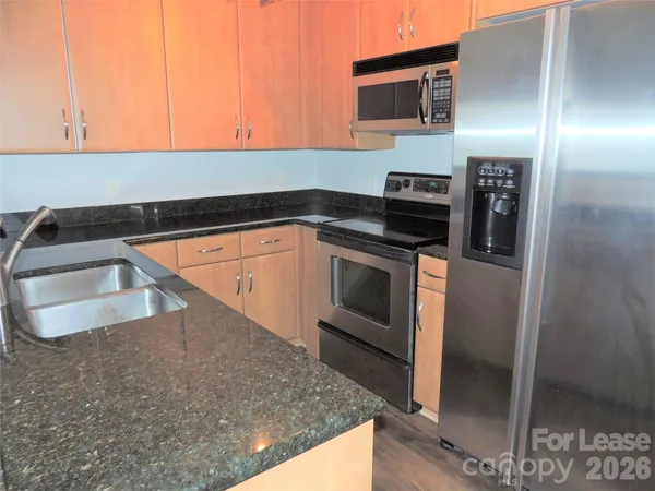 a kitchen with stainless steel appliances granite countertop a sink and a stove