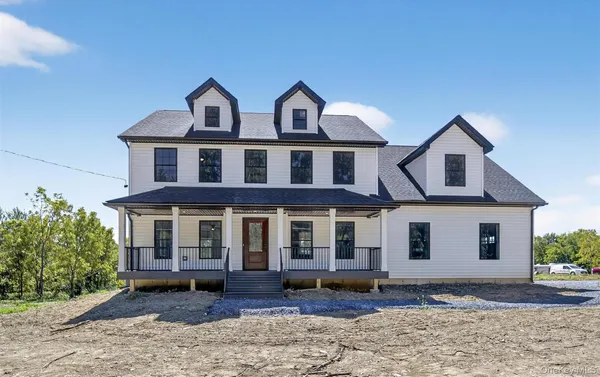 a view of a white house with large windows next to a yard