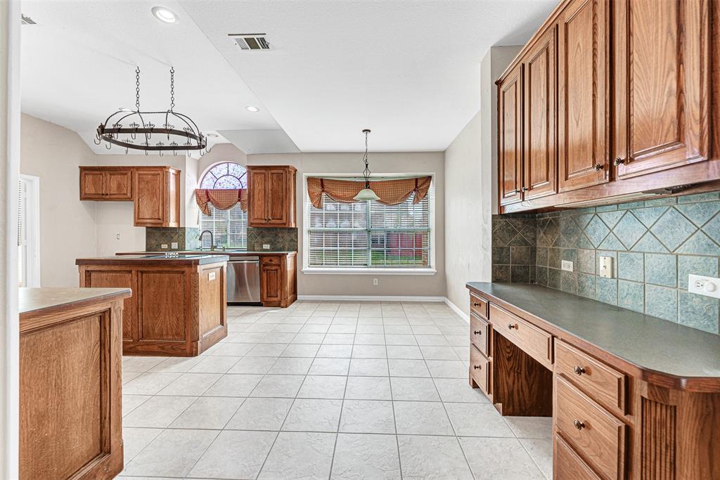 3500 Neiman Road Plano, TX 75025 - Photo 11 of 29 a kitchen with granite countertop a stove a sink and dishwasher wooden cabinets with granite countertops